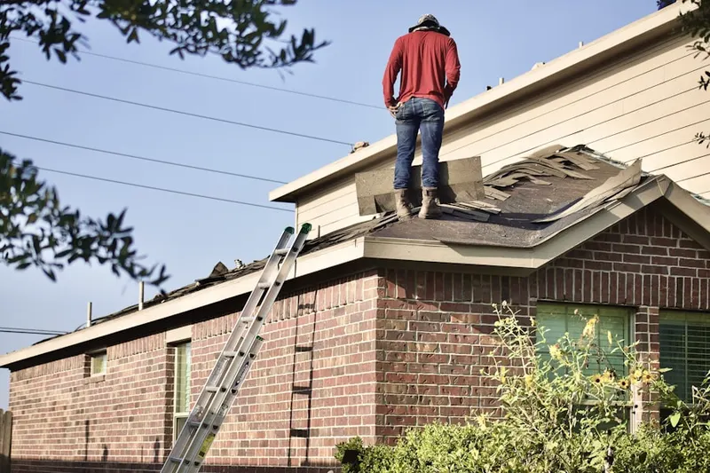 Professional roofer working on a residential roof in Lee